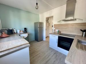 cocina con nevera y encimera en Superbe appartement dans une résidence avec garage - 137, en Bihorel