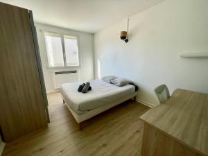 ein kleines Schlafzimmer mit einem Bett und einem Fenster in der Unterkunft Superbe appartement dans une résidence avec garage - 137 in Bihorel