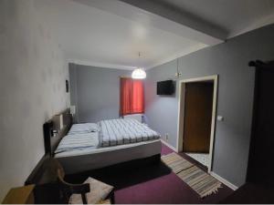 ein kleines Schlafzimmer mit einem Bett und einem Fenster in der Unterkunft Hotel Zum Ritter in Staufenberg