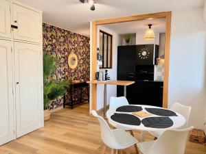 eine Küche und ein Esszimmer mit einem Tisch und Stühlen in der Unterkunft Le Point Virgule - Parking Privé - Climatisation in Montauban