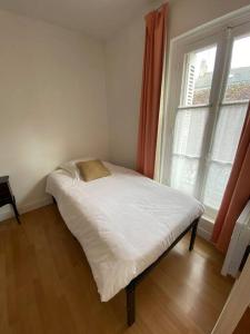 uma pequena cama num quarto com uma janela em Logement de groupe à Villandry avec terrasse em Villandry
