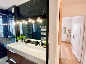 a bathroom with a sink and a large mirror at Le Point Virgule - Parking Privé - Climatisation in Montauban