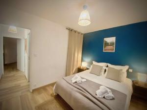 1 dormitorio con 1 cama grande y toallas. en Le Point Virgule - Parking Privé - Climatisation, en Montauban