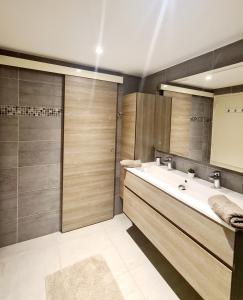 uma casa de banho com um lavatório e um chuveiro em MAGNIFIQUE APPARTEMENT VUE MER - GRANDE TERRASSE ET PISCINE em Bandol
