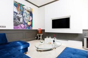 a living room with a blue couch and a tv at Villa Maiffret YourHostHelper in Cannes