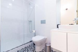een witte badkamer met een toilet en een douche bij Oporto Near Coliseu in Porto