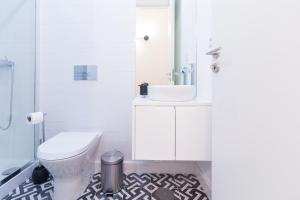 ein Badezimmer mit einem weißen WC und einem Waschbecken in der Unterkunft Oporto Near Coliseu in Porto