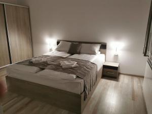 a bedroom with a large bed and a night stand at Апартамент Time for us in Velingrad
