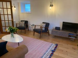 a living room with a couch and chairs and a tv at The Old Chapel Manton in Manton