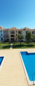 an empty swimming pool in front of a building at Beach Apartment Villa Columbus in Vilamoura