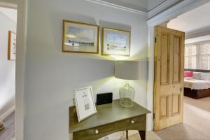 a room with a desk with a lamp and a bedroom at Stylish 2 Bedroom Maisonette With Parking in Harrogate