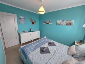 um quarto com paredes azuis e uma cama com duas toalhas em Apartamento Lily - FuerteventuraBay em Costa de Antigua