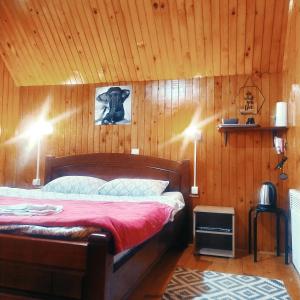 a bedroom with a bed in a wooden wall at Apartmani Božana Vojinović in Žabljak