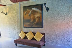 a painting of a horse on a wall next to a couch at Castillo Inspiracion Hostel in Bocas del Toro