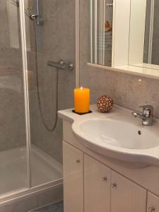 a bathroom with a sink and a candle on a counter at Ferienwohnung Pyhrgasblick in Rosenau am Hengstpass