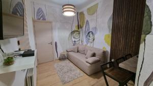 a living room with a couch and a painting on the wall at Ancora apartment Anja in Novi Sad