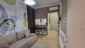 a living room with a couch and a kitchen at Ancora apartment Anja in Novi Sad