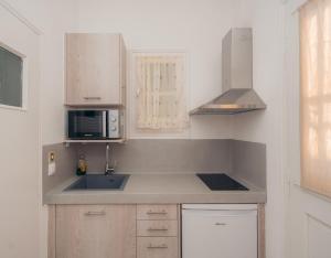 a kitchen with a sink and a microwave at Giannakas Studios in Platis Yialos Sifnos