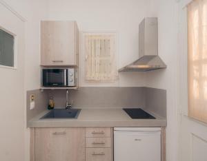 a kitchen with a sink and a microwave at Giannakas Studios in Platis Yialos Sifnos