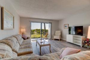 a living room with a couch and a tv at Yellow Sunshine Oceanfront Townhouse, Private Balcony in Ponce Inlet
