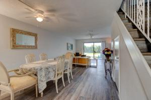 a dining room with a table and chairs and a staircase at Blue Skies Oceanfront 2 bedroom townhouse in Ponce Inlet