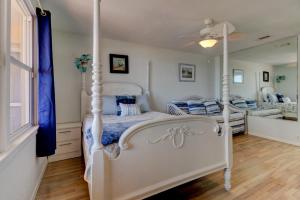 a bedroom with a white canopy bed and a window at Beachfront 4 Bedroom 4 Bath with Huge Deck Wifi in Daytona Beach