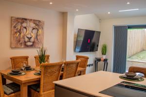 jadalnia ze stołem i krzesłami oraz obrazem lwa w obiekcie BV Comfy Spacious 3 Bedroom TownHouse At One Cliff Oak Leeds Perfect For Contractors w mieście Leeds
