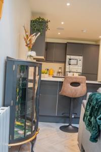 a kitchen with gray cabinets and a stool in a room at BV Comfy Spacious 3 Bedroom TownHouse At One Cliff Oak Leeds Perfect For Contractors in Leeds