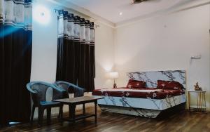 a bedroom with a bed and a table and chairs at SR Residence in Kaliānpur
