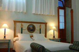 a bedroom with a bed and two lamps and a chair at DUI classic/BB con Wifi y piscina en Yaiza in Yaiza