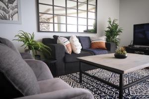 a living room with a couch and a coffee table at Beachfront Gem / Free Parking / A/C in Cape Town