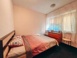 a bedroom with a bed and a dresser and a window at Guest House near Railway Station in Kyiv