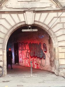 a man walking through a tunnel covered in graffiti at HISTORIC ROYAL MILE FLAT , 5min FROM WAVERLY RAILWAY STATION in Edinburgh