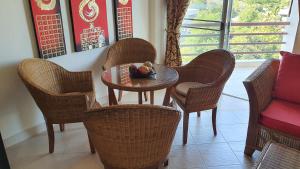 una mesa y sillas con un bol de fruta. en Double Superior Condo Rayong with seaview - 7th floor free wifi en Rayong