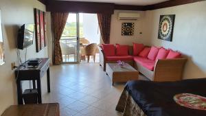 a living room with a red couch and a tv at Double Superior Condo Rayong with seaview - 7th floor free wifi in Rayong