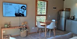 una cucina con tavolo e TV a parete di Casa Bosque a San Carlos de Bariloche