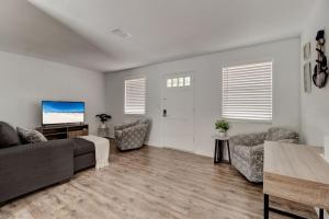 a living room with a couch and a flat screen tv at Coquina Cabana with fenced yard and adorable decor in South Daytona +7 photos