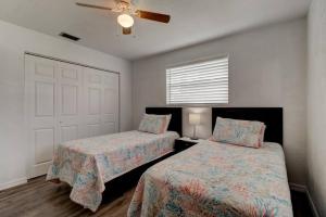 a bedroom with two beds and a ceiling fan at Coquina Cabana with fenced yard and adorable decor in South Daytona