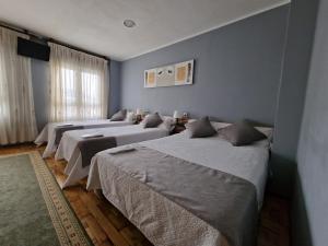 três camas num quarto com paredes azuis em Hostal Fidalgo em Oviedo