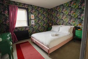 a bedroom with a bed with floral wallpaper at Central Belfast Apartments Unique Retreat in Belfast