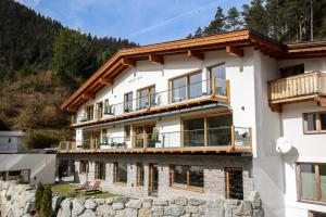 a house in the mountains with a balcony at Monte Vita Tirol - Apartments in Biberwier