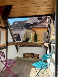 2 Stühle auf einem Balkon mit einem Dach in der Unterkunft La Mariana - Old Town Cosy Apartments in Colmar