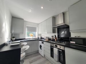Η κουζίνα ή μικρή κουζίνα στο Lovely 2 - Cozy Retreat Modern 2-Bedroom Flat in Bedfordshire with Fully-Equipped Kitchen and Relaxing Living Space