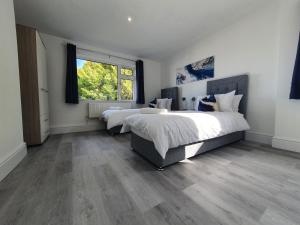 Ένα ή περισσότερα κρεβάτια σε δωμάτιο στο Lovely 2 - Cozy Retreat Modern 2-Bedroom Flat in Bedfordshire with Fully-Equipped Kitchen and Relaxing Living Space