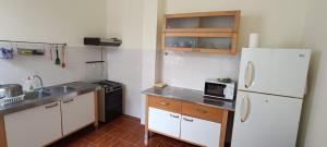 a kitchen with a white refrigerator and a sink at Hostel Mindelo in Mindelo