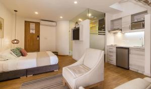 カルタヘナ・デ・インディアスにあるLuxury 1BR suite Rooftop 201のベッドルーム1室(ベッド1台、椅子1脚付)、キッチン