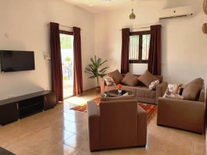 a living room with couches and a flat screen tv at CASA LOKO Guest House in Luxor