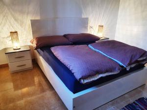 een slaapkamer met een groot bed met 2 nachtkastjes bij CASA LOKO Guest House in Luxor