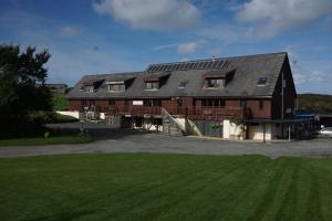 une grande grange brune avec des panneaux solaires dans l'établissement Anglesey Outdoors, à Holyhead