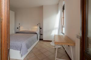 sypialnia z łóżkiem i drewnianym stołem w obiekcie MIZAR- Appartamento privato con parcheggio gratuito by Appartamenti Petrucci w mieście Foligno